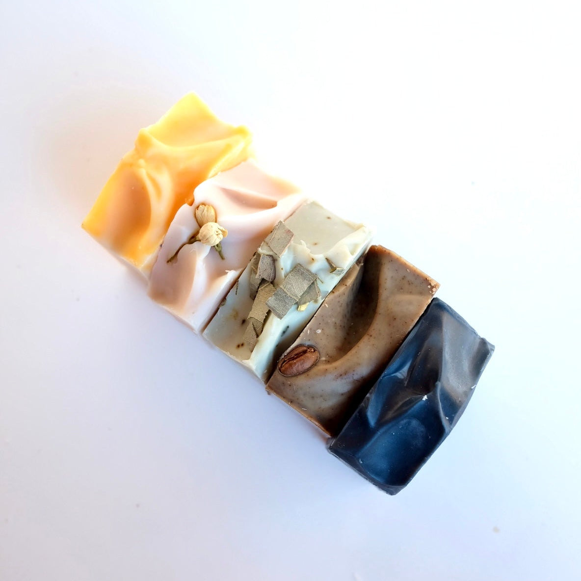 Stack of multicoloured natural tallow soap bars on a white background