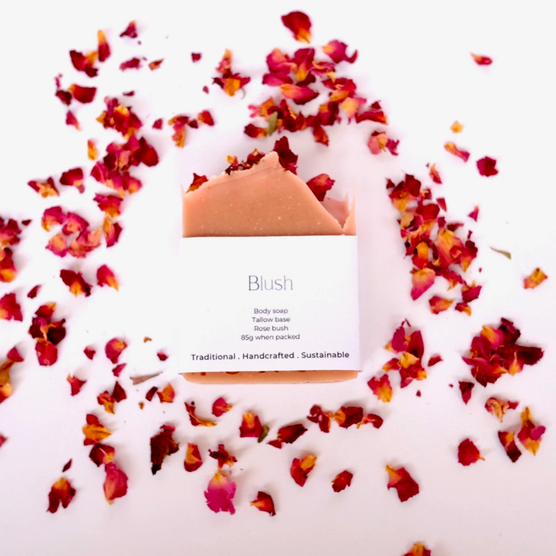 Body wash bar with 'Blush' branding surrounded by red and pink flower petals on a white background