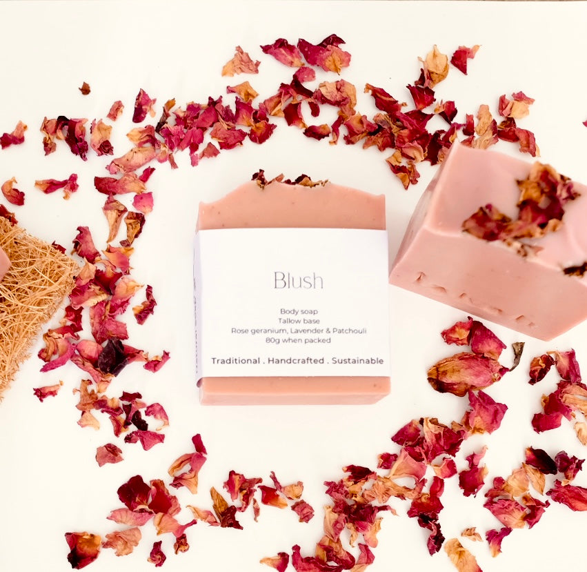 Tallow soap labeled 'Blush' with dried rose petals on a white background