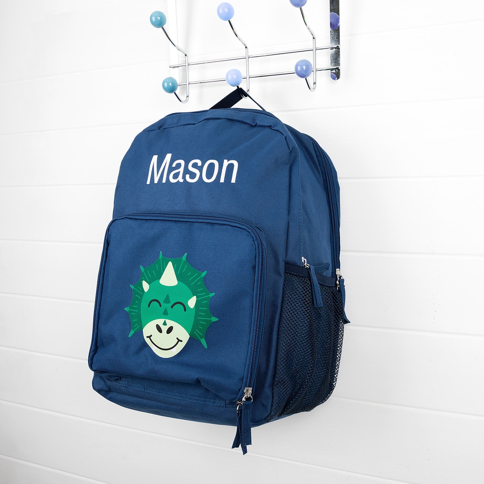 Personalised navy kids backpack with dinosaur print and child's name embroidered.