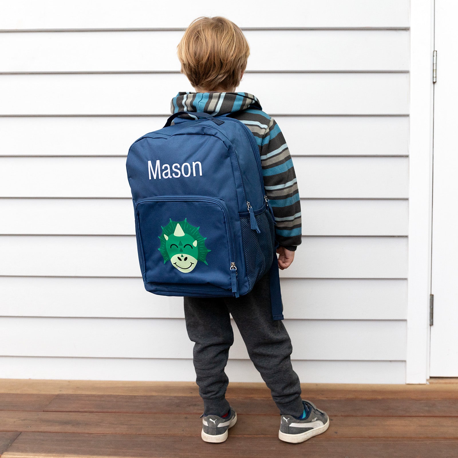 Young child wearing a personalised dinosaur backpack, showcasing the comfortable fit and playful design perfect for preschool.