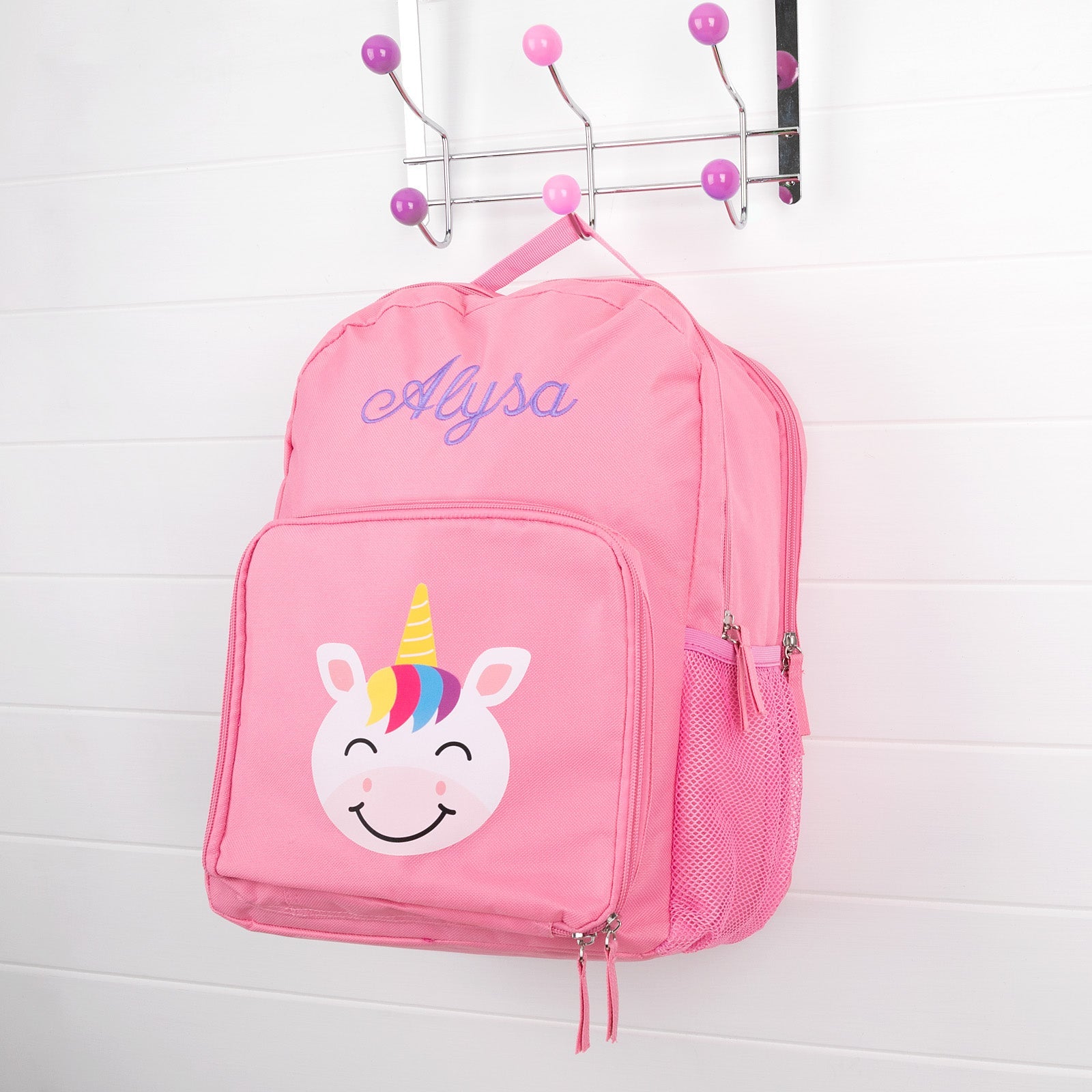 Pink personalised kids backpack with embroidered child's name and smiling unicorn face print.