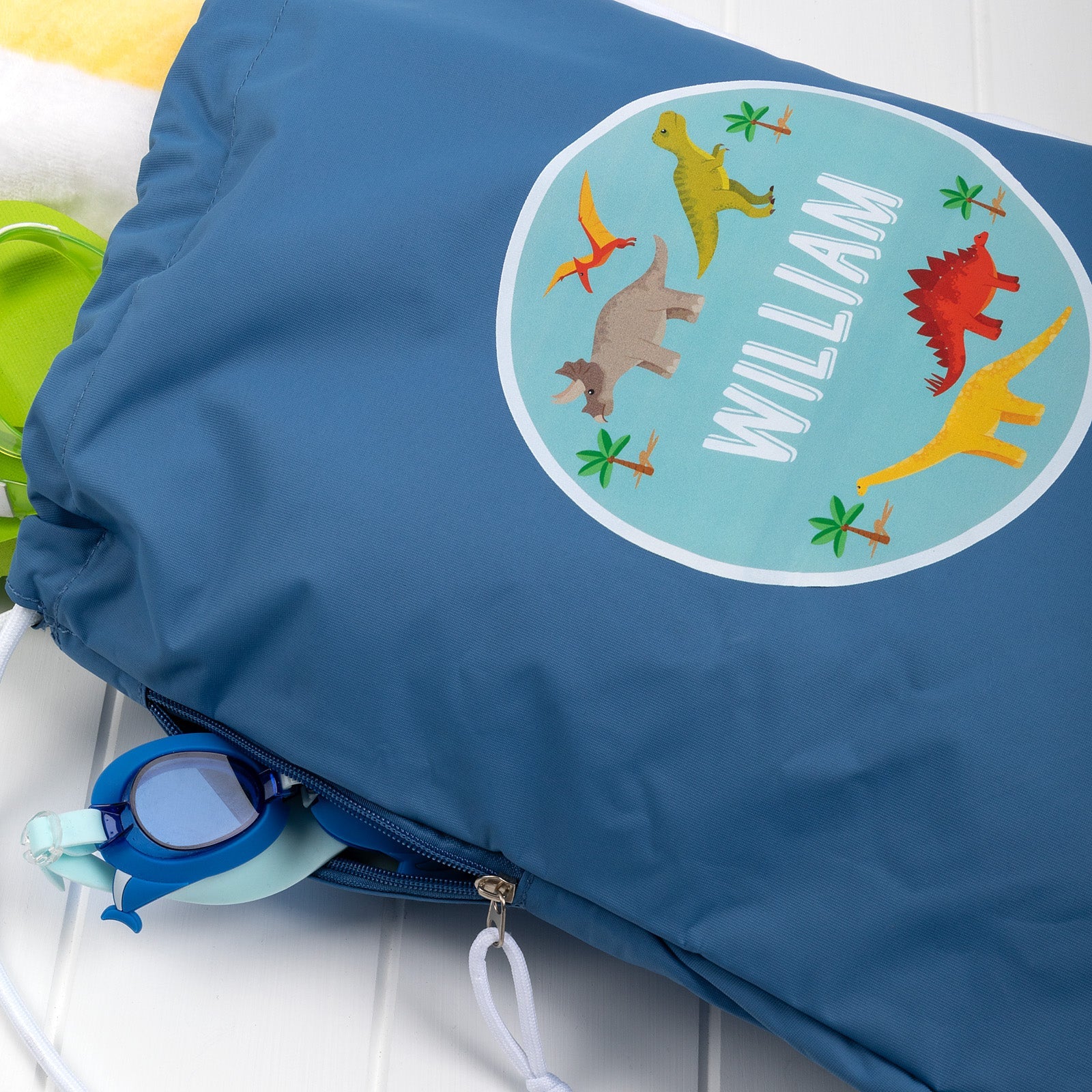 Close-up of personalised swim bag showing fun dinosaur artwork and side zip pocket.