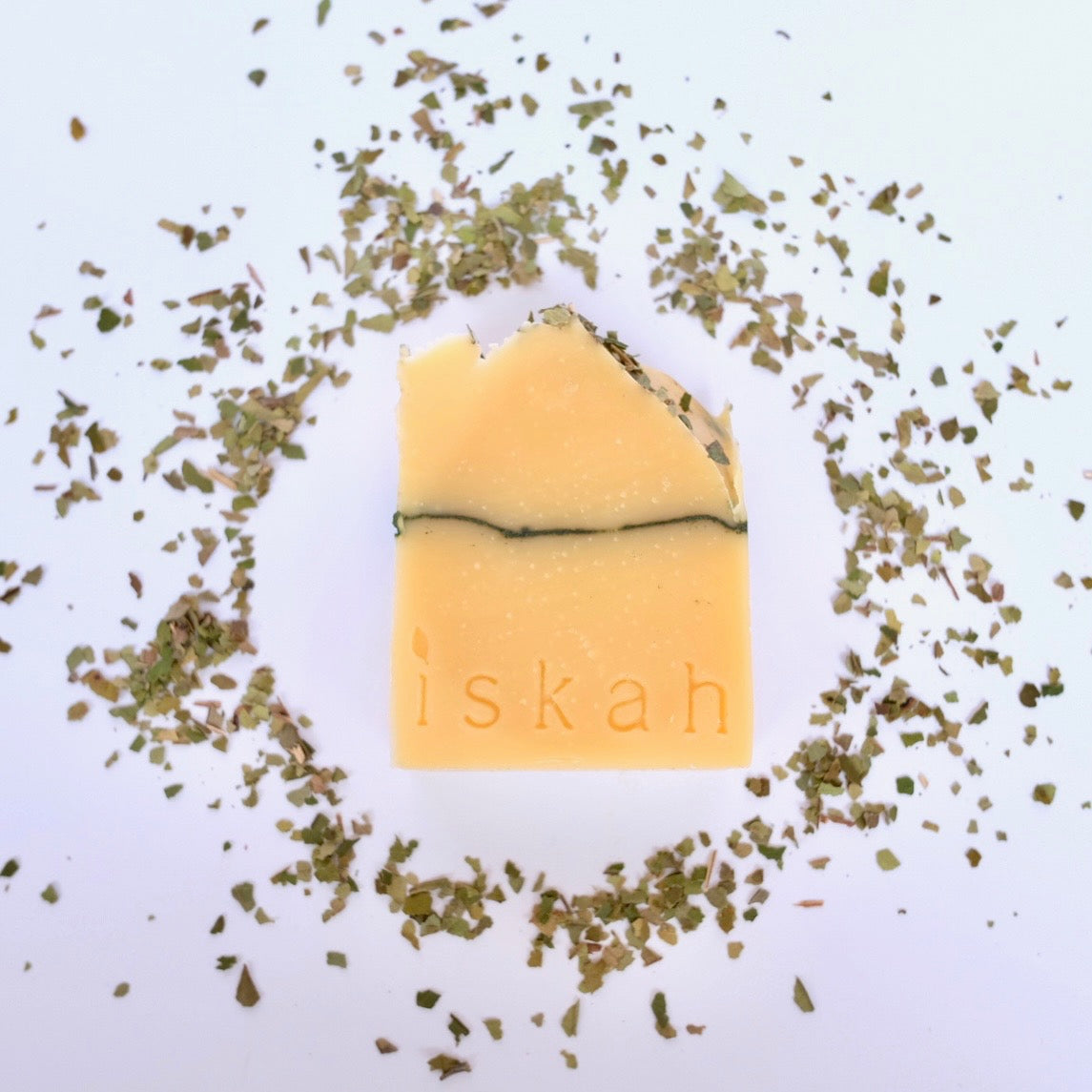 tallow soap bar with iskah stamped on it surrounded by lemon myrtle leaves