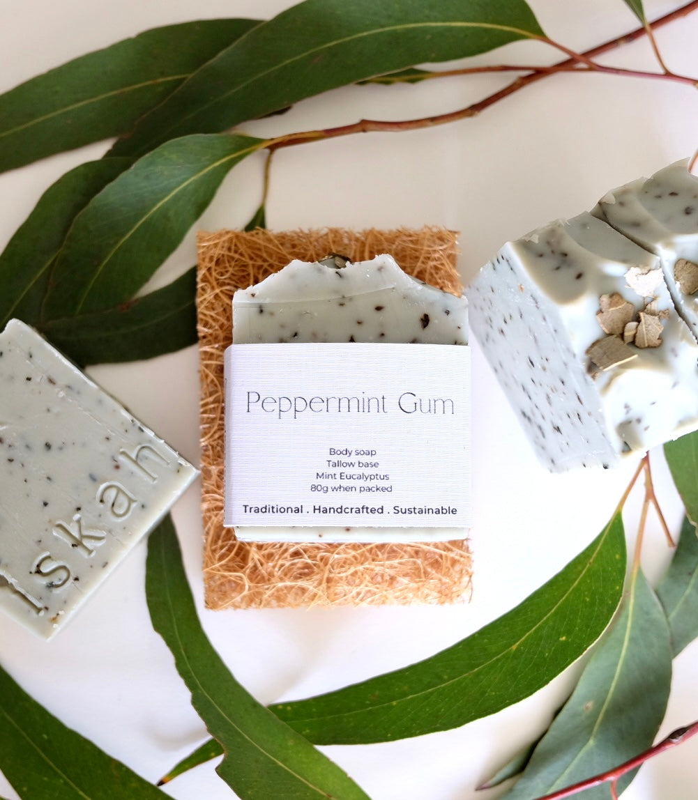 Bar of peppermint gum scented tallow soap sitting on a coconut soap rest