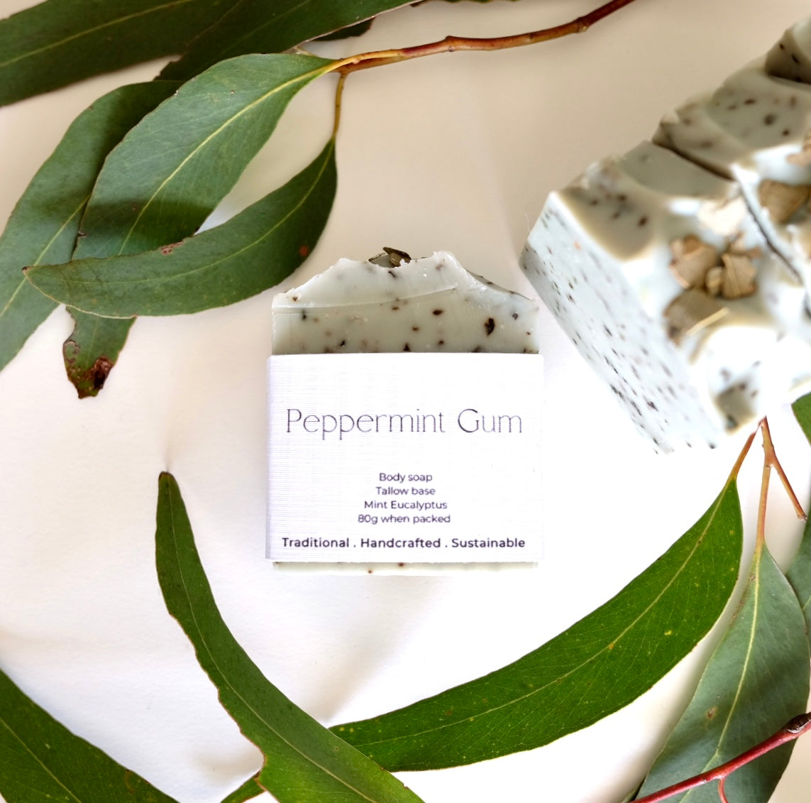 Tallow soap bar of peppermint gum and french green clay soaps surrounded by gum leaves